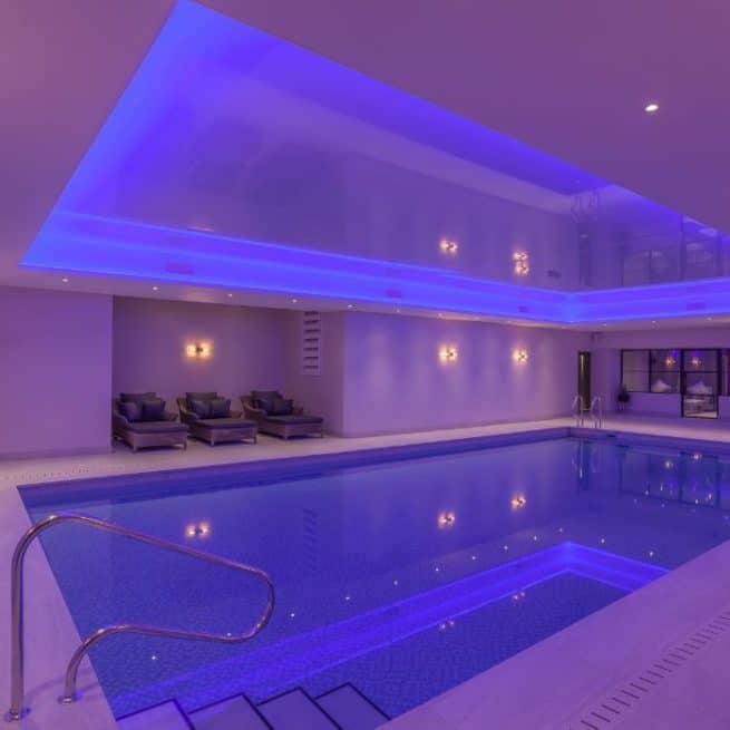 Indoor swimming pool with purple lighting at The Alchemist Spa in the Woolacombe Bay Hotel